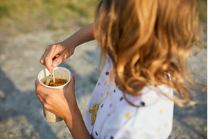 Child enjoying a snack on a sunny, a Food & Drink Photo by IlliaBondarPhotography