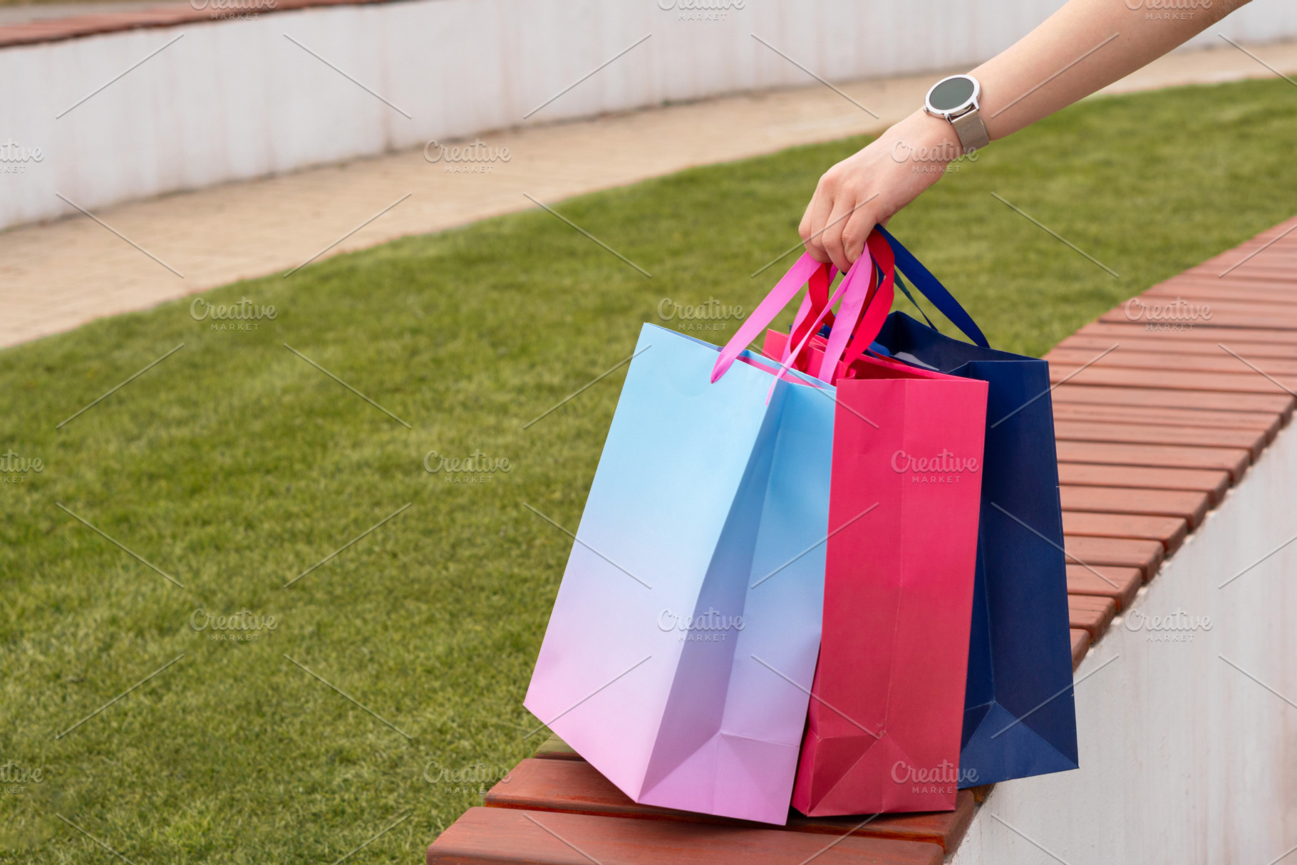 Person placing vibrant shopping bags, a Background Photo by Elena Vagengeim