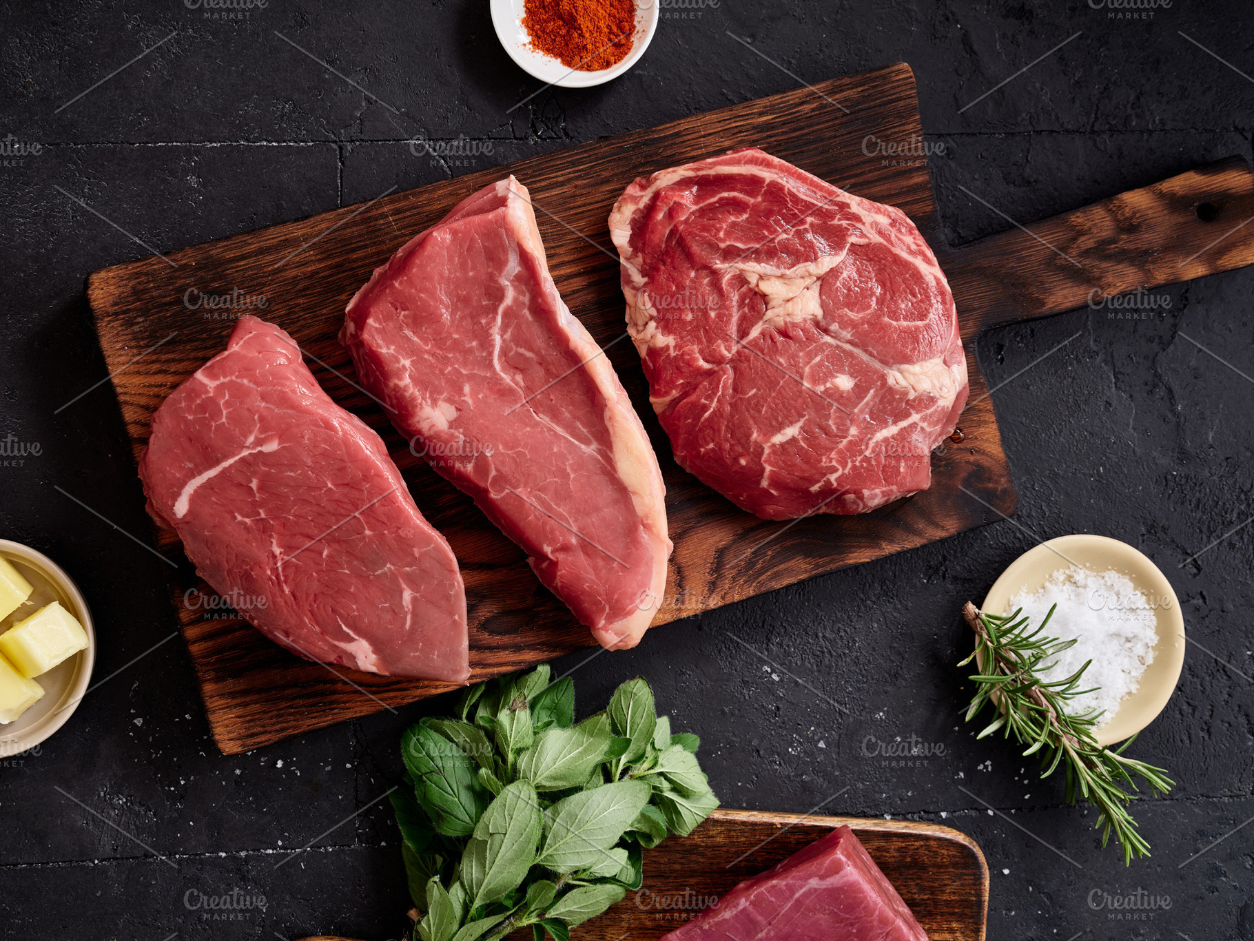 Raw rib-eye, roast beef, flank and rump steak placed on a wooden cutting board, a Food & Drink Photo by Asya Nurullina