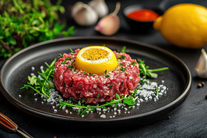 Beef tartar garnished with lemon, a Photo by Pavel_design