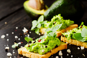 Toast with a paste of avocado and pesto basil spices containing avocado