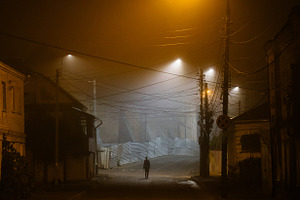 Lonely woman walking in foggy city