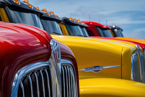 Colorful semitrucks parked in a row, a Photo by Pavel_design