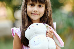Portrait of a cute little girl smiling and holding a plush bunny toy., a Person Photo by Rohan Photography