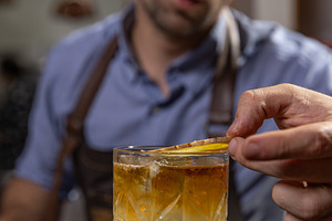 Bartender carefully garnishing a cocktail