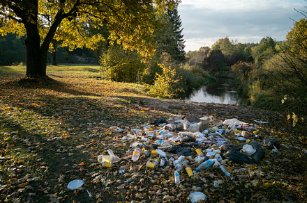 Garbage pile in forest. Rubbish heap after picnic near river. En