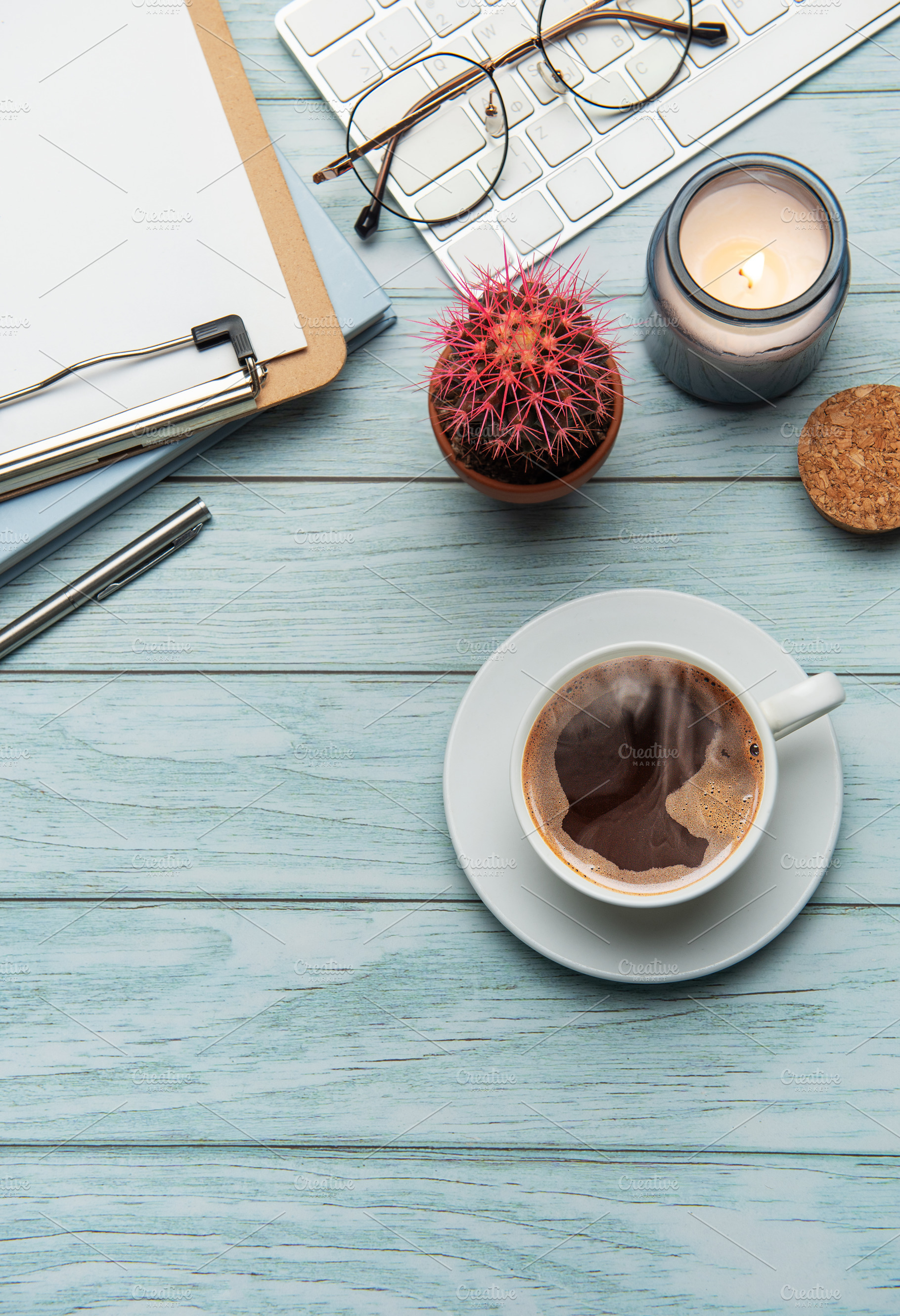Office desk with coffee, keyboard, and supplies on light blue wo, a Business Photo by Olena Rudo