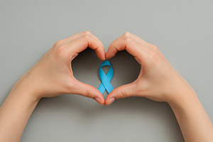 Men health awareness ribbon between hands symbolizing mens healt, a Photo by Dvoevnore photos