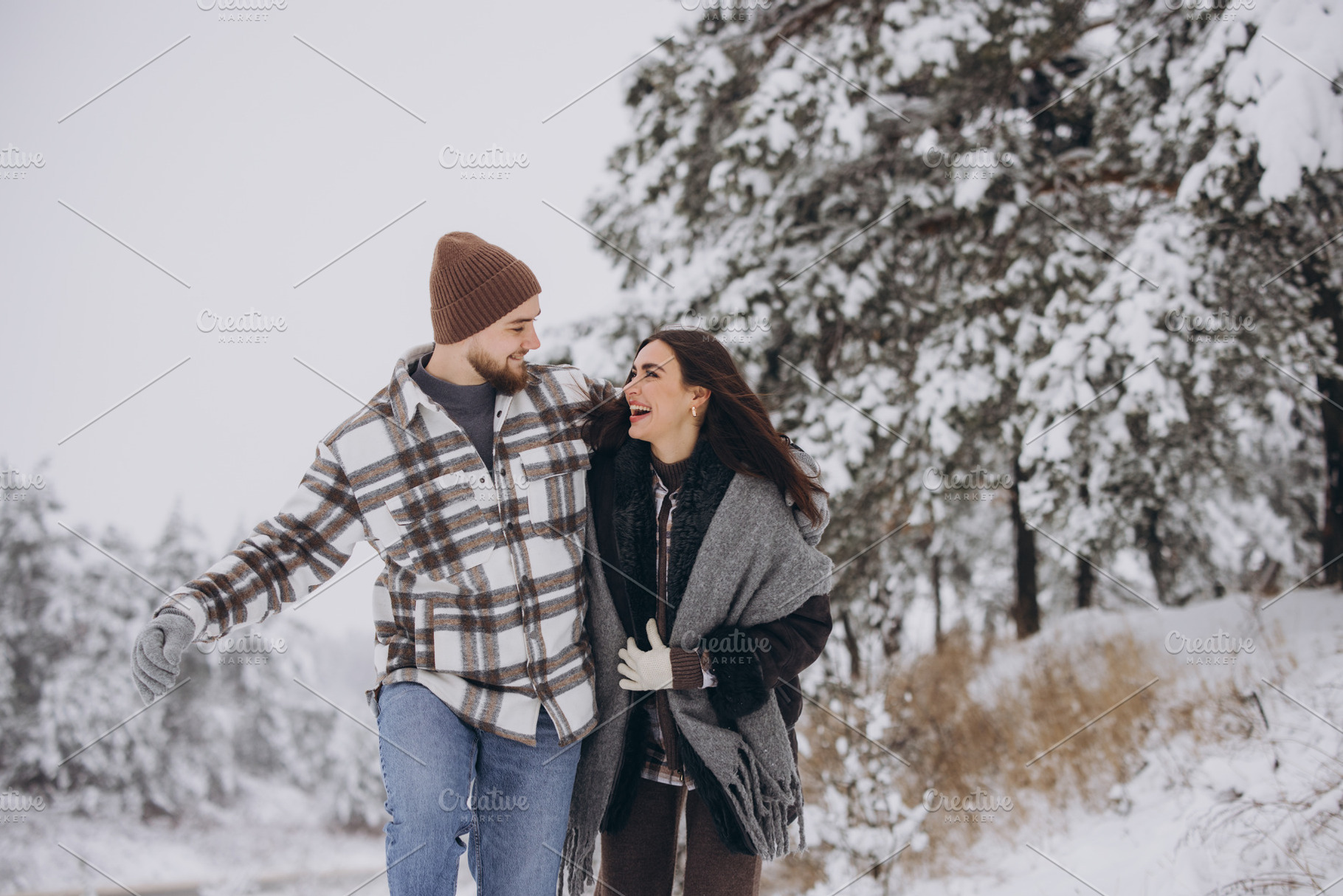 A young happy and loving couple walking in a winter snowy forest, a Person Photo by Cherkas Photography