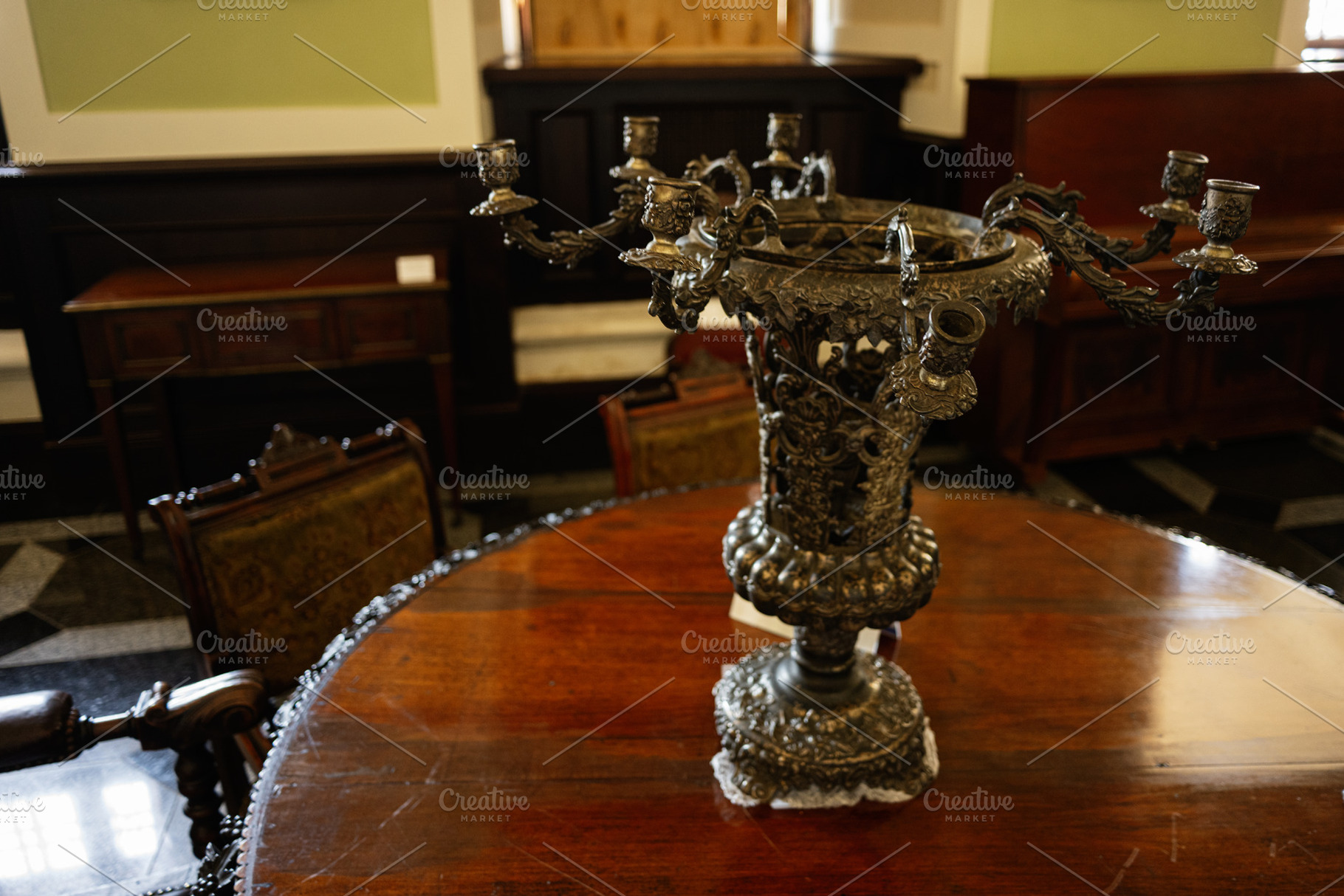 Ornate antique candelabra on a polished wooden table in a classic interior, a Photo by AS photostudio