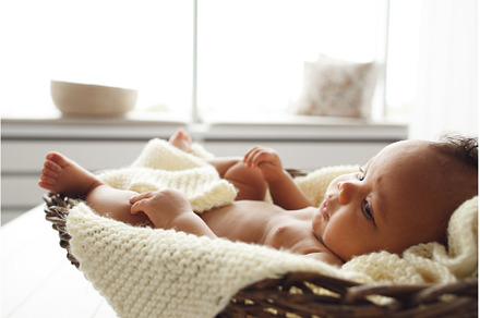 Adorable baby lying in wicker cradle, a Person Photo by Photo Drive Studio