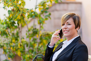 Businesswoman talking on smartphone outdoors, a Photo by RF Images