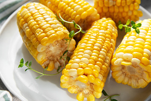Boiled sweet corn on the cob serving with fresh herbs, a Food & Drink Photo by Olena Rudo