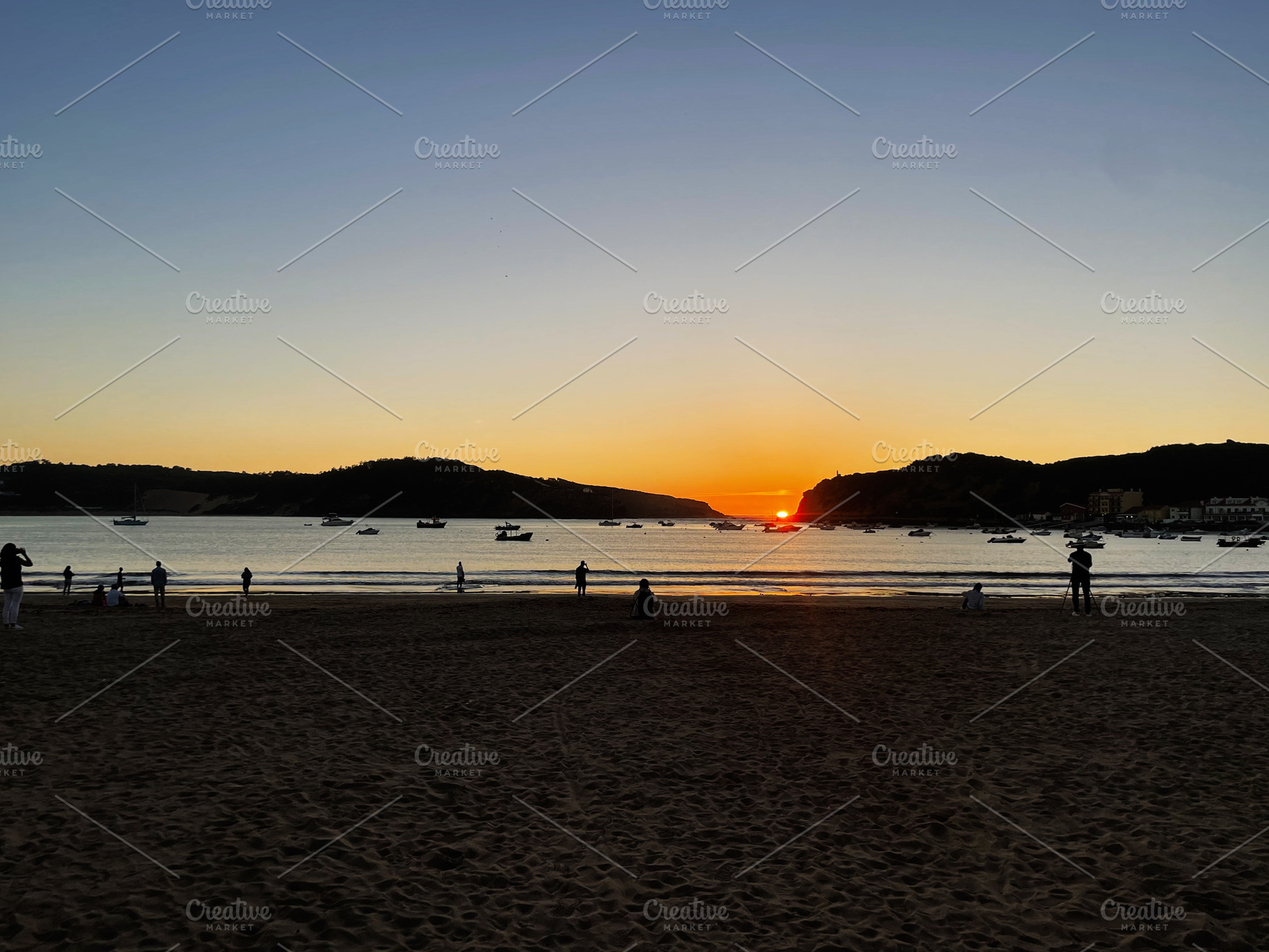 Sunset view over the bay with boats and people on the sandy coast, a Photo by AS photostudio