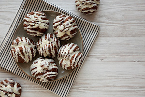 Homemade Profiteroles with Coconut Cream on a Plate, top view. C, a Food & Drink Photo by LiudmylaChuhunova