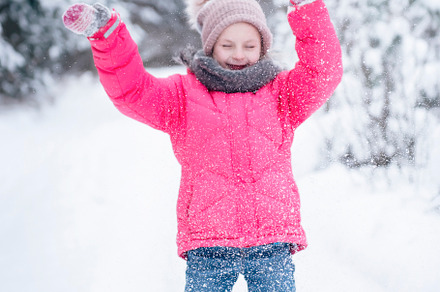 Little girl in a bright jacket plays in the winter forest, a Person Photo by Olena Rudo
