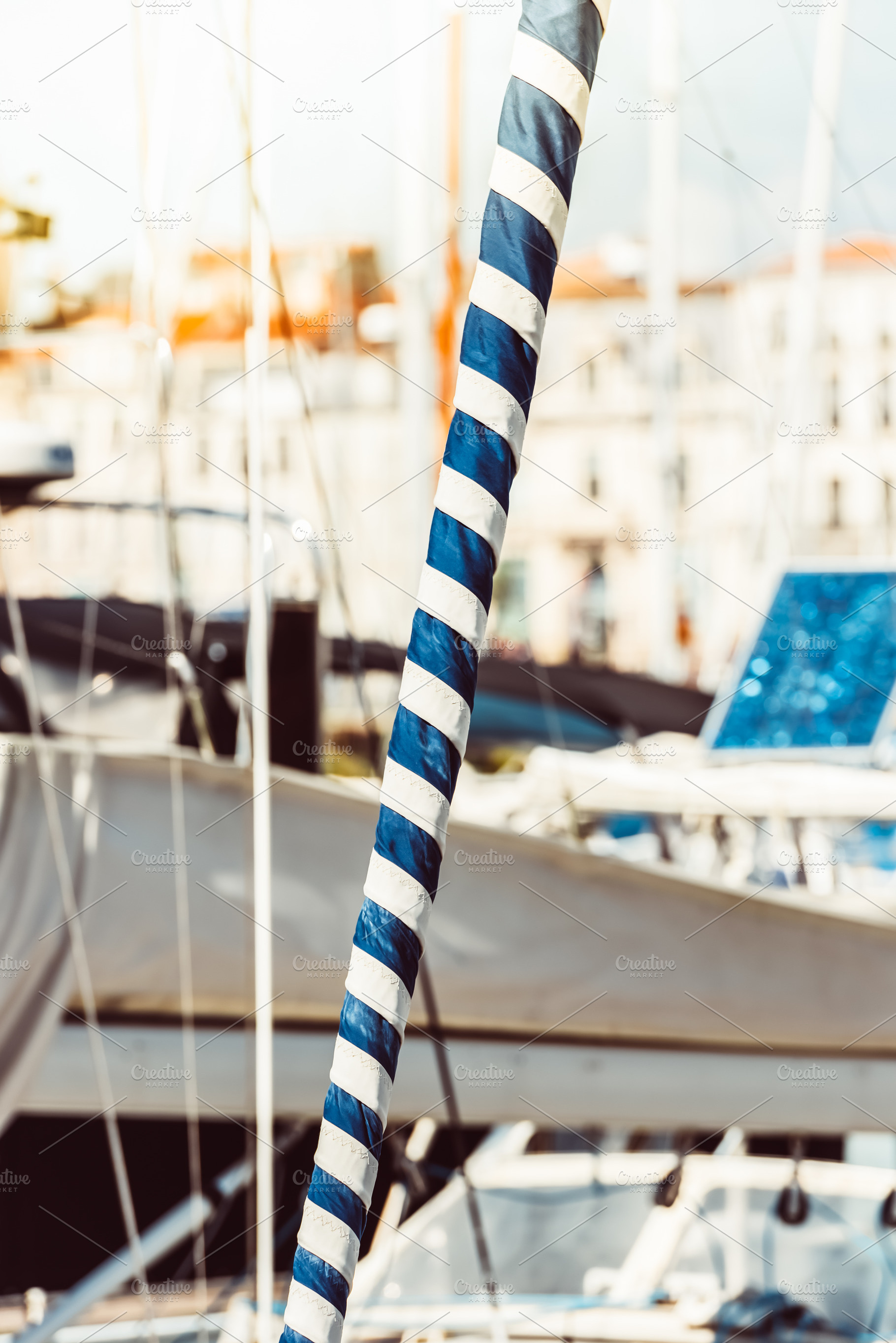 Sailboat mast with blue and white st, a Photo by Dvoevnore photos