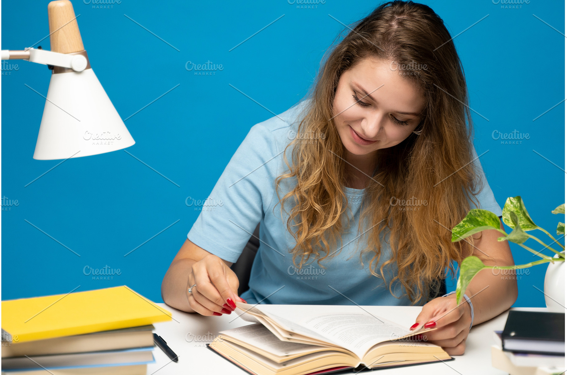 Woman reading book at desk with, a Person Photo by volodymyrshtun13795