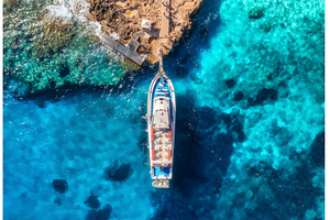 Aerial view of boat and rocky sea, a Nature Photo by den-belitsky