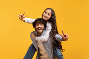 Romantic indian couple having fun together, showing V-sign gesture, guy piggyba, a Photo by Prostock-Studio (Thumbnail 4 of 4)
