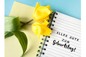 Yellow tulips on a notebook with, a Photo by tilialucida