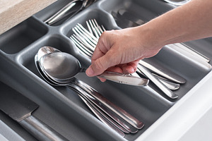 Hand picking up a spoon from an organized kitchen drawer, a Food & Drink Photo by etorres69