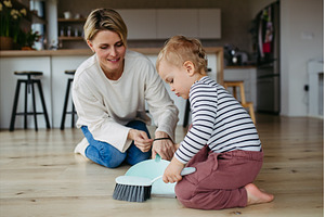 Mother teaching toddler to sweep the, an Architecture Photo by HalfPoint