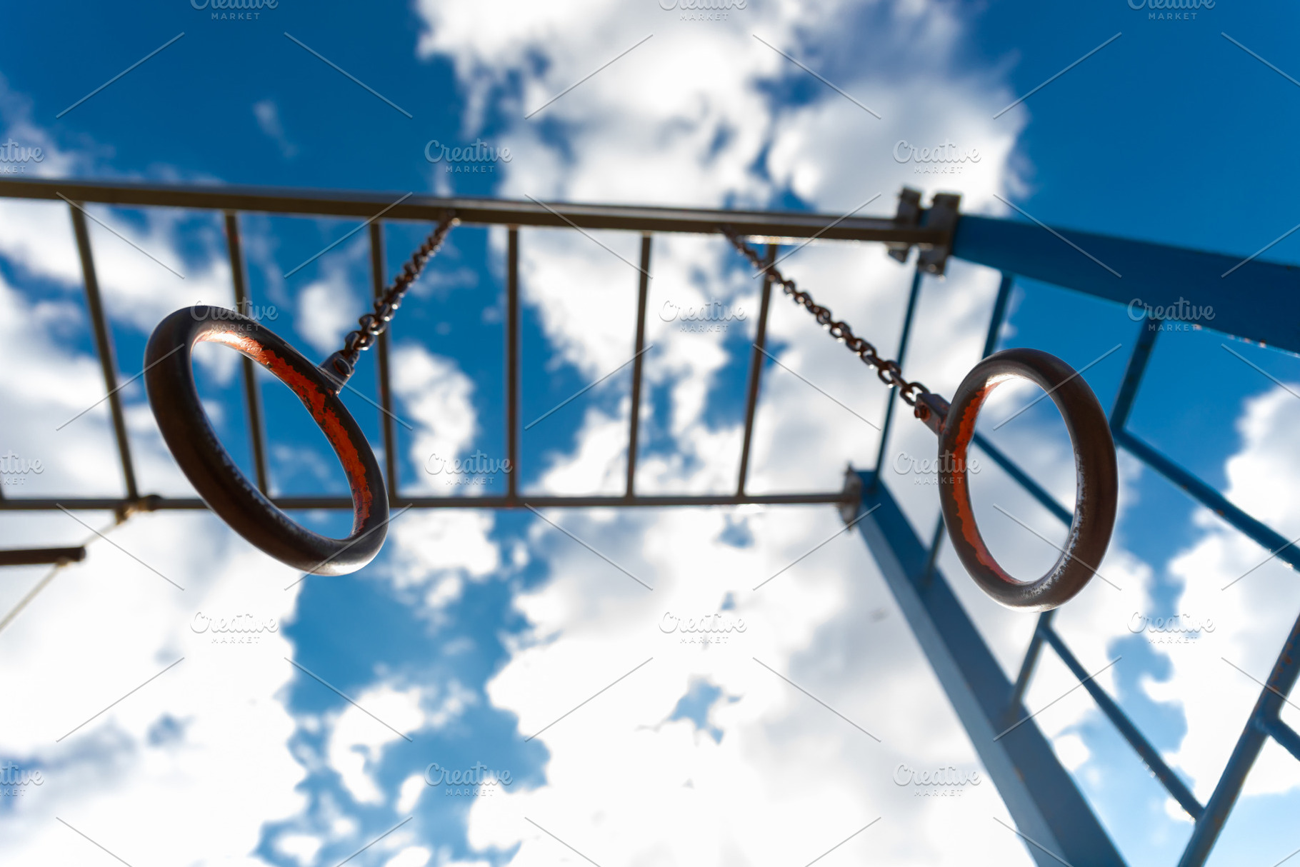 Upward view of metal gymnastic rings hanging from chains, with a, a Sports & Recreation Photo by Ales Munt