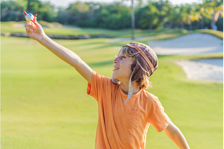 Boy wearing a pilot hat running