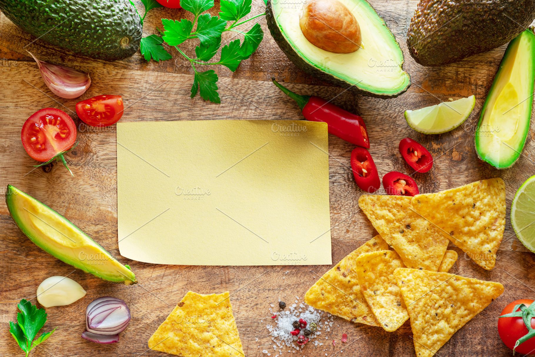 Blank paper and guacamole ingredients arranged as a frame on woo, a Food & Drink Photo by Volff