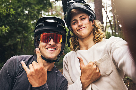 Friends in forest, cool fitness selfie fitness with cycling helmet and smile with hands gesture in Australia. Workout on bicycle trail, fun travel adventure and outdoor sports training in green woods, a Photo by Peopleimages.com