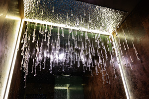 Modern ceiling with hanging glass droplets illuminated by warm lights, a Photo by AS photostudio