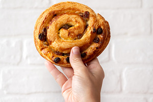 Hand Holding Raisin Danish Pastry, a Food & Drink Photo by etorres69