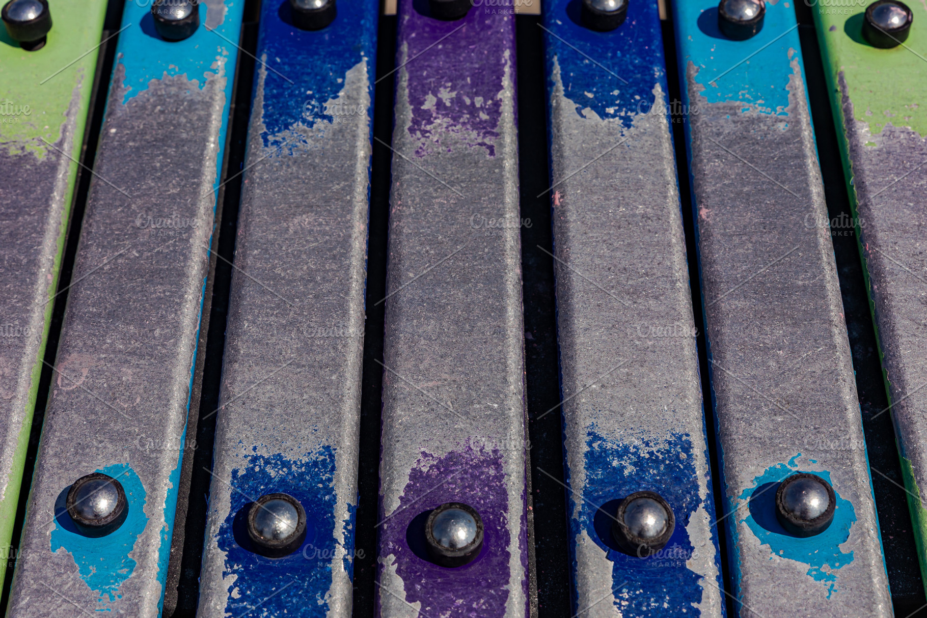 Vibrant close-up of metallic xylophone bars with colorful painted accents, perf, a Person Photo by Ales Munt