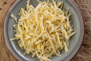 Shredded cheese waiting in a plate, a Photo by Grafvision photography