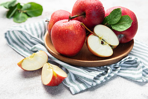 Fresh red apples in wooden bowl with slices, a Food & Drink Photo by Olena Rudo