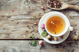 White cup of aromatic tea on wooden table, a Food & Drink Photo by AlyaAnd