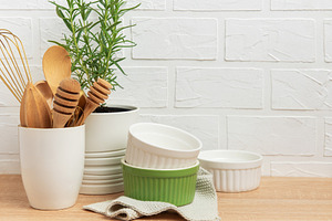Kitchen utensils, rosemary plant, and ramekins creating a cozy c, a Food & Drink Photo by Olena Rudo