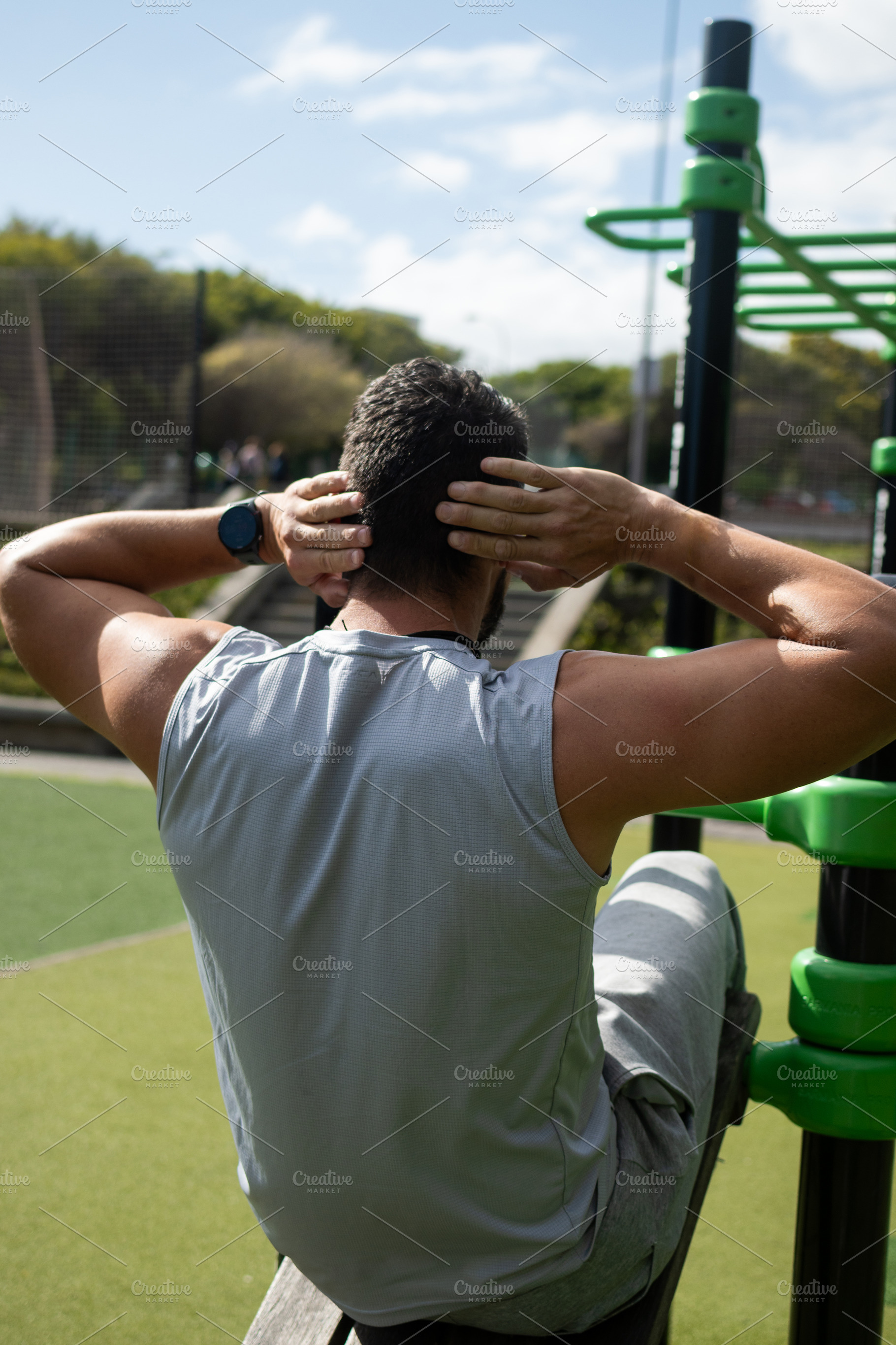 Young athletic man doing sit-ups exercise outdoors in park, a Food & Drink Photo by etorres69
