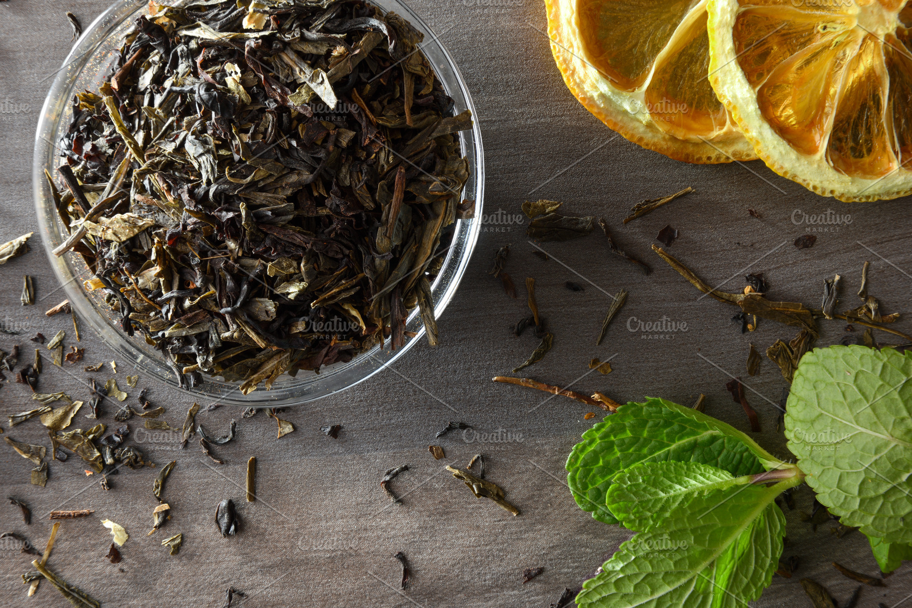 Glass bowl filled with dried tea leaves lemon and mint, a Food & Drink Photo by Davizro's Market