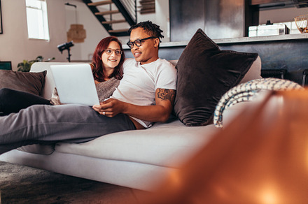 Couple relaxing on sofa at home containing african, apartment, and authentic, a Person Photo by Jacob Lund
