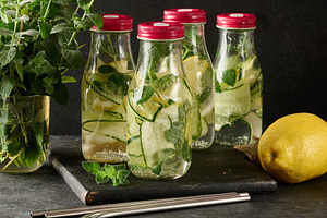 Group of glass bottles with red lids, filled with detox water, c, a Food & Drink Photo by ndanko