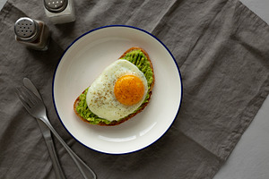 Homemade Avocado Toast with Egg on a Plate, top view. Space for, a Food & Drink Photo by LiudmylaChuhunova