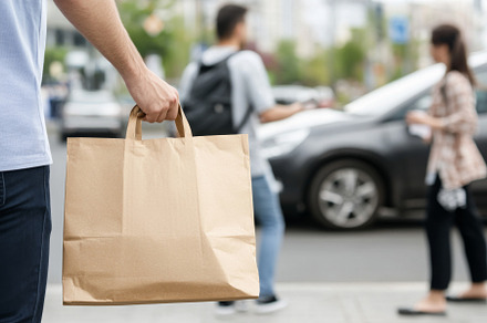 Brown paper bag held on city street,, a Photo by Dvoevnore photos