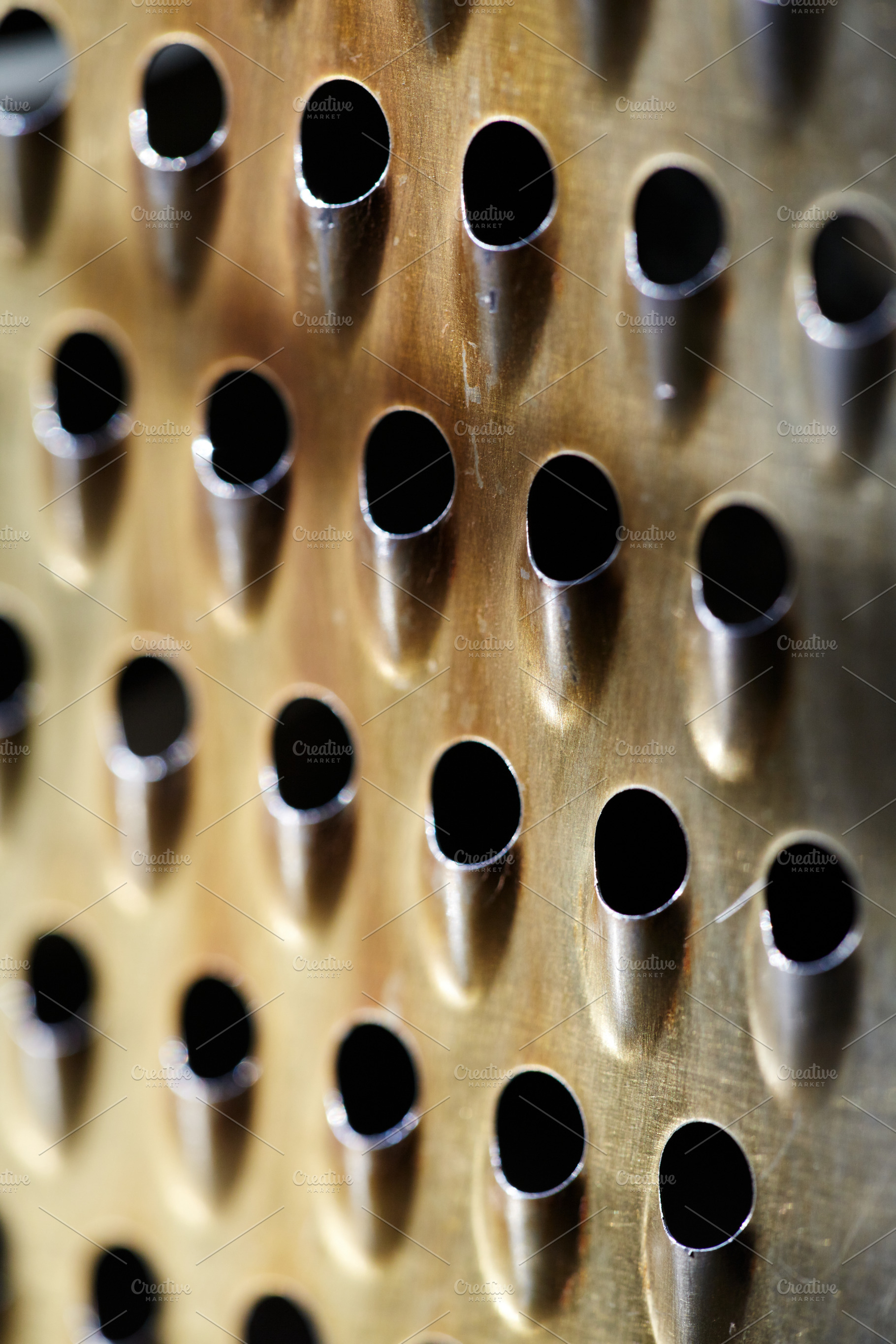 Close-up of a rustic kitchen tool with rhythmic perforated holes. Macro of oxid, a Background Photo by Rohan Photography
