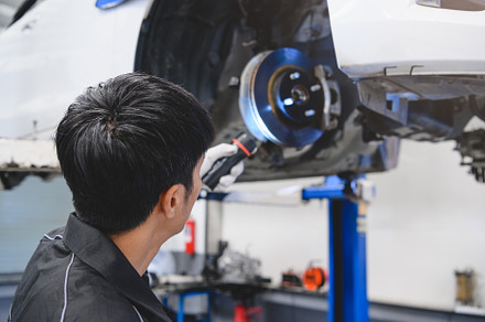 Asian male mechanical hold and shining flashlight to examine car, an Industrial Photo by Ministocker
