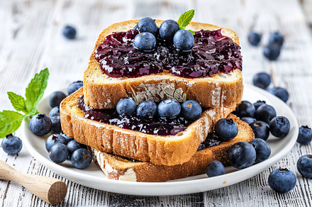 Toast breads with sweet blueberry jam on wooden table, a Food & Drink Photo by AlyaAnd
