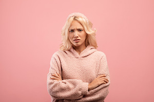 Offended lady standing with folded arms and looking at camera, grumpy woman fee, a Photo by Prostock-Studio