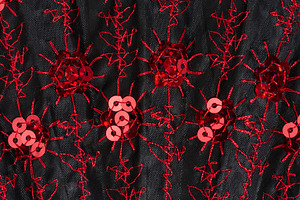 Black fabric with red embroidery and shiny sequins close-up, a Beauty & Fashion Photo by ndanko