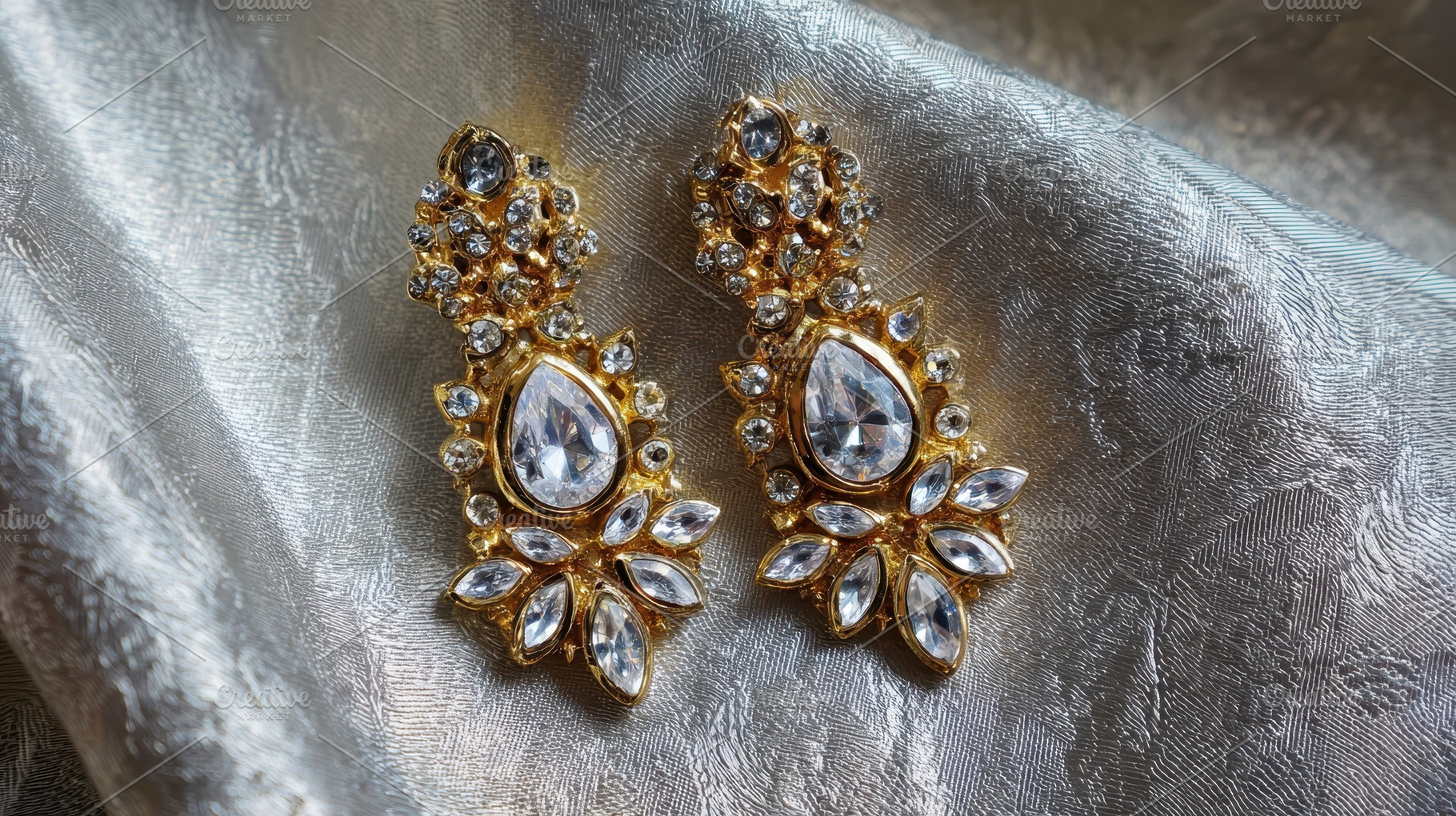 A pair of earrings rests on a fabric, a Photo by Pavel_design